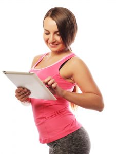 Young sporty woman using a digital tablet after workout